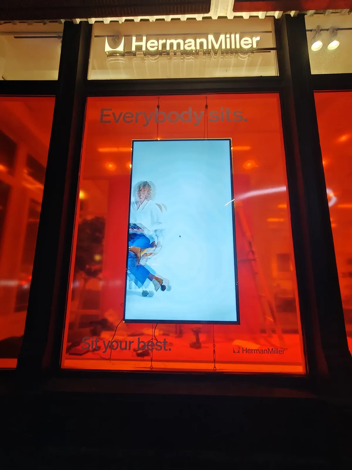 Herman Miller Park Avenue showroom window with a Samsung QM75C in portrait