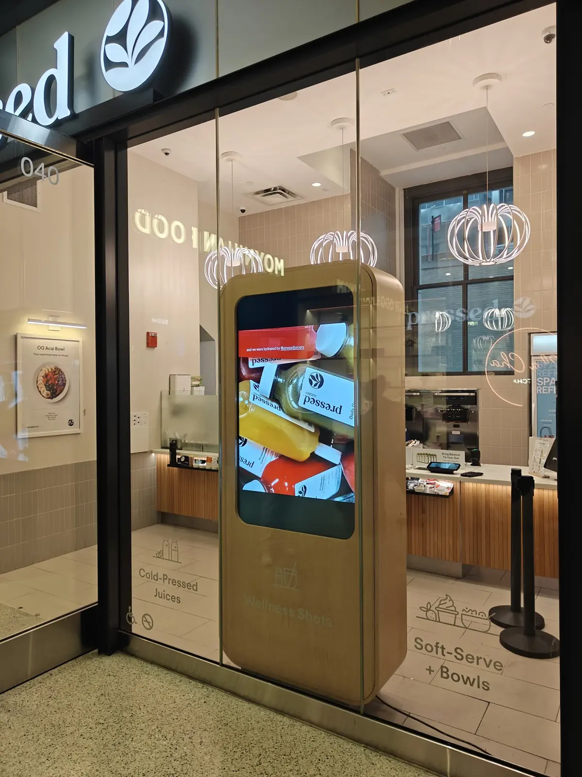 Pressed Juicery birch kiosk at Penn Station with a Samsung OM55B display